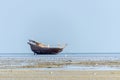 An old fishing dhow stranded at low tide in quiet shallow waters Royalty Free Stock Photo