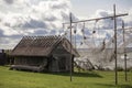 an old fishing net with buoys dries on poles and flutters in the wind against a background of a wooden house and the sea Royalty Free Stock Photo