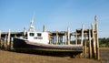 A weathered lobster boat tied to a jetty at low tide in the maritimes