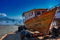 Old fishing vessel,Antique wooden boat. old fishing vessel on the beach sand for repair on a sunny day and blue sky Royalty Free Stock Photo