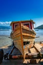 Old fishing vessel,Antique wooden boat. old fishing vessel on the beach sand for repair on a sunny day and blue sky Royalty Free Stock Photo