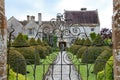 An old flag stone path leads up to an English country house viewed through a wrought iron gate. The path is bordered by elegant Royalty Free Stock Photo