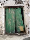 Old flaking broken green door in white wall in Fuerteventura Canary Islands