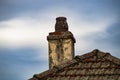 Old Flaking Chimney Pot on Tiled Roof Royalty Free Stock Photo