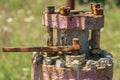 An old flange with rusty bolts and peeling paint abandoned in the field after the end of oil production. Pollution of Royalty Free Stock Photo