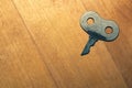 Old flat key on wooden background
