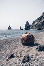 Old rusty round floating marine mines on the beach with rocky shore and sea background. Pollution, nature protection