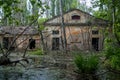 Old flooded overgrown ruined abandoned forsaken industrial building among bog after the flood disaster