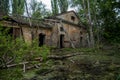 Old flooded overgrown ruined abandoned forsaken industrial building among bog after the flood disaster