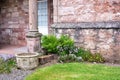Old Flower Pots, Flowers And Ferns By A Stone Wall Of A House