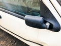Old folded broken black plastic mirror of a white passenger car Royalty Free Stock Photo