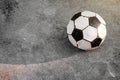 Old football. Black and white soccer ball is placed on the concrete ground Royalty Free Stock Photo