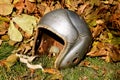 Old football helmet left laying in the leaves Royalty Free Stock Photo