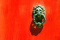 Old forged maltese handle on the red door Royalty Free Stock Photo