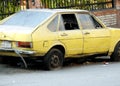 old forgotten retro rusty dirty yellow car parked in the street with damaged tires, dusty broken car, rusty wreck