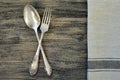 Old fork and spoon and towel on wooden background close up. Royalty Free Stock Photo