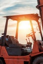 Old Forklift transporting cargo on a road near the sea with sunset time