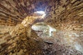 Old forsaken empty basement room of ancient building or palace with cracked plastered brick walls, low arched ceiling, small Royalty Free Stock Photo