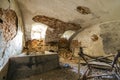 Old forsaken empty basement room of ancient building or palace with cracked plastered brick walls, low arched ceiling, small Royalty Free Stock Photo
