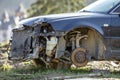 Old forsaken rusty broken trash car after crash accident without wheels on wood stamps covered with snow on winter day outdoors