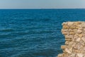 Old fortress in the rocks above the sea. Rocky cliff in the ancient at the top. Stone boulders sticking out of the Royalty Free Stock Photo