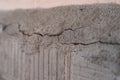 Old foundation and plaster wall with cracks. Building requiring repair closeup. Royalty Free Stock Photo