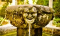 Old fountain decorated with demonic faces
