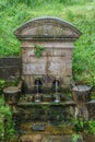 Old fountain poursing water from two spouts Royalty Free Stock Photo