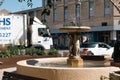 Old fountain in the street in Cheltenham city with sunny building in the background