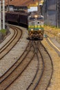 Old freight train worn out by time and use arriving in the city Royalty Free Stock Photo