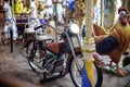 Old French carousel in a holiday park. Bike on traditional fairground vintage . Merry-go-round with . Royalty Free Stock Photo