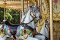 Old French carousel in a holiday park during sunny day. Horses on a traditional fairground vintage carousel. Merry-go-round with Royalty Free Stock Photo