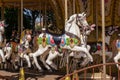 Old French carousel in a holiday park during sunny day. Horses on a traditional fairground vintage carousel. Merry-go-round with Royalty Free Stock Photo