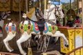 Old French carousel in a holiday park during sunny day. Horses on a traditional fairground vintage carousel. Merry-go-round with Royalty Free Stock Photo