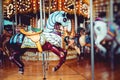Old French carousel in a holiday park. Three horses and airplane on a traditional fairground vintage carousel. Merry-go-round with Royalty Free Stock Photo