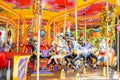 Old French carousel in a holiday park. Three horses on a traditional fairground vintage carousel. Merry-go-round with Royalty Free Stock Photo