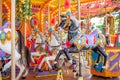 Old French carousel in a holiday park. Three horses on a traditional fairground vintage carousel. Merry-go-round with Royalty Free Stock Photo