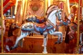 Old French carousel roundabout, galloper with illumination at an amusement in a holiday park. Horse on a traditional Royalty Free Stock Photo