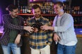 Old friends meeting. Happy young men in casual wear toasting with beer while sitting in beer pub together Royalty Free Stock Photo