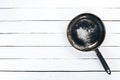 An old frying pan on a wooden background. Royalty Free Stock Photo