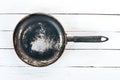 An old frying pan on a wooden background. Royalty Free Stock Photo