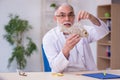 Old funny male zoology teacher demonstrating fish skeleton