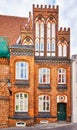 Old gabled house facade with small towers made of red brick in the old town of Wismar