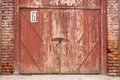 Old garage door in a white concrete wall. Gates made of wood painted with cracked green paint Royalty Free Stock Photo