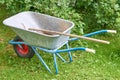 Old garden iron cart in the garden on a green lawn with a shovel