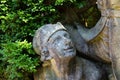 Old garden statue detail, face of a young boy in a hat looking up, aged and heavily weathered Royalty Free Stock Photo