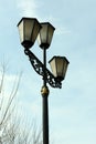 An old gas lantern against the background of bare willow branches and a clear blue sky Royalty Free Stock Photo