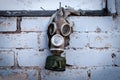 Old gas mask with coal filter hung on the brick wall. Concept - Nuclear Disarmament and Radiation Protection, epidemic,