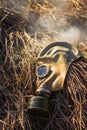 Old gas mask in smoke on the ground isolated. Straw in smoke.