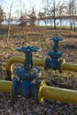 Old gas pipes with large overlapping taps are laid underground in the yard Royalty Free Stock Photo